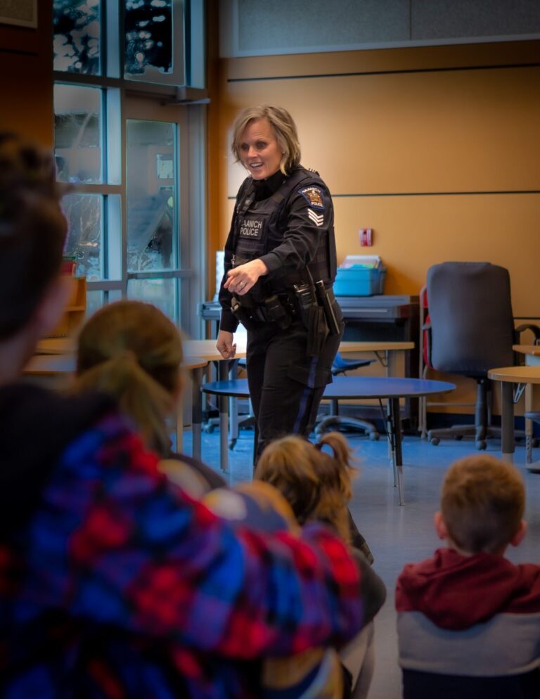 photo showing a female police officer speaking to a number of young children in school